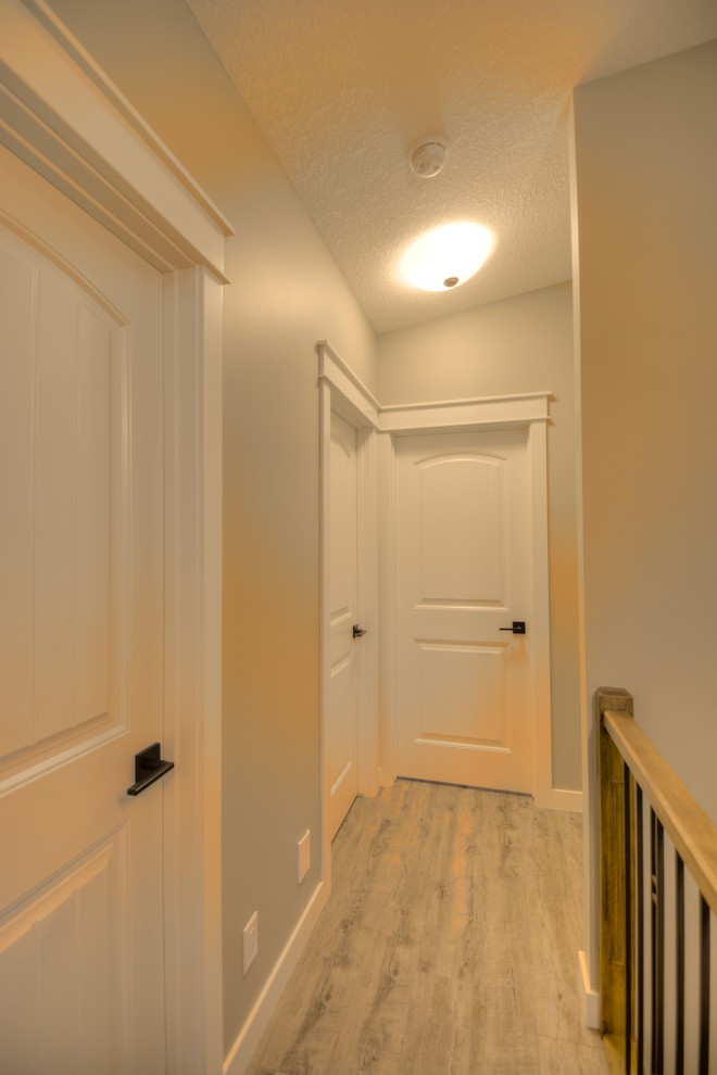 Стильный дизайн: коридор среднего размера: освещение в стиле модернизм с серыми стенами и полом из ламината - последний тренд