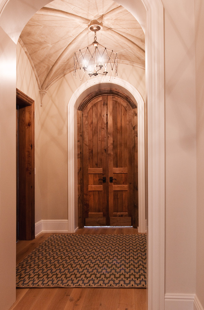 Idée de décoration pour un grand couloir champêtre avec un mur blanc et un sol en bois brun.