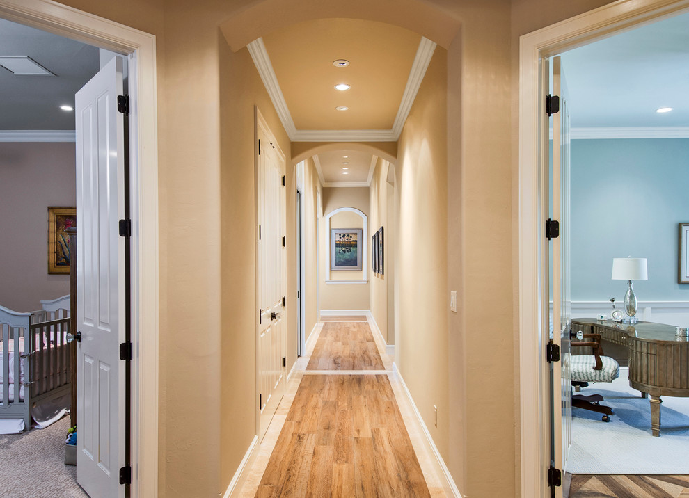 Inspiration pour un grand couloir traditionnel avec un mur beige et un sol en bois brun.