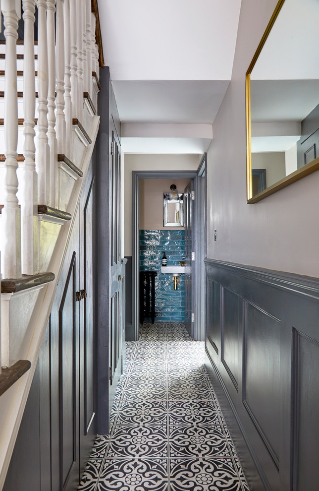 Réalisation d'un petit couloir minimaliste avec un mur gris, un sol en carrelage de céramique et un sol blanc.