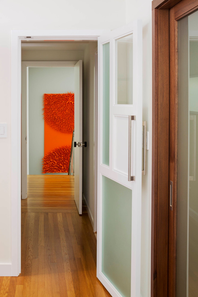 Immagine di un ingresso o corridoio contemporaneo di medie dimensioni con pareti bianche e pavimento in legno massello medio