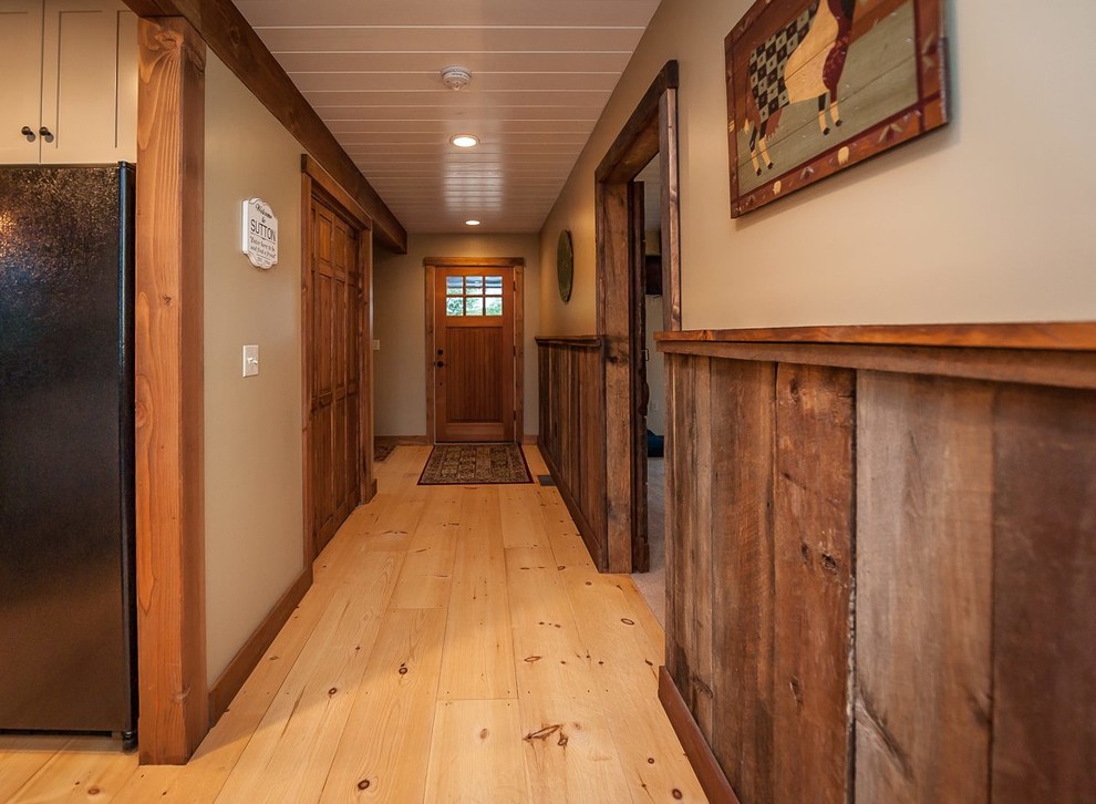 Ejemplo de recibidores y pasillos rurales de tamaño medio con paredes beige y suelo de madera clara