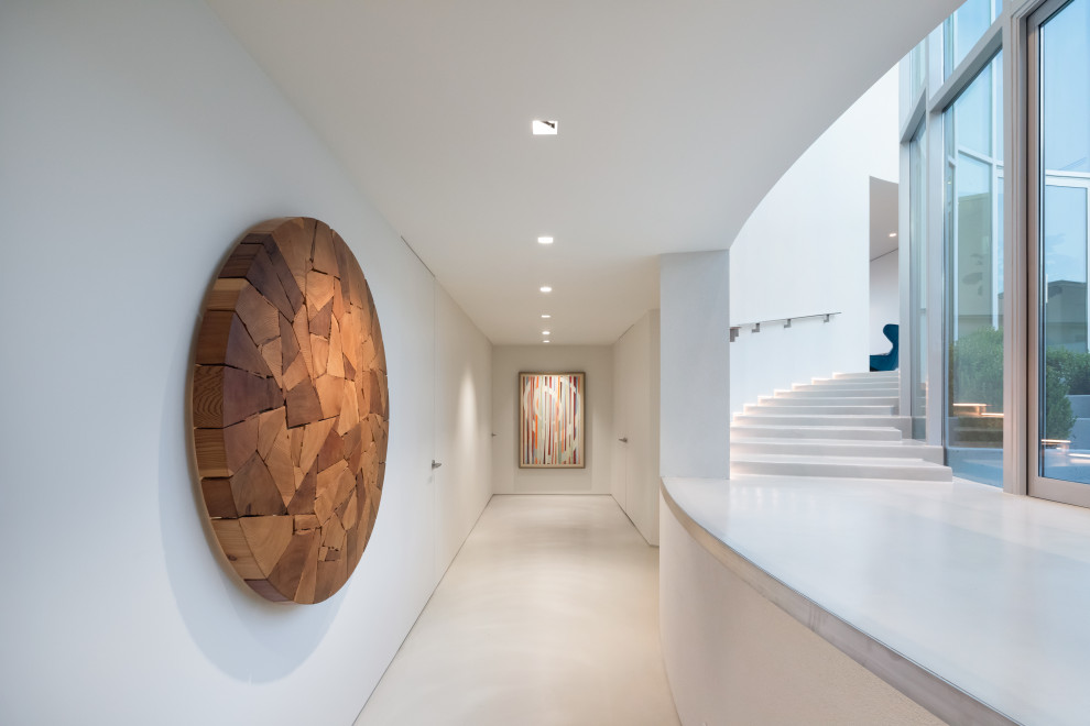 Свежая идея для дизайна: большой коридор в современном стиле с белыми стенами, бетонным полом и серым полом - отличное фото интерьера