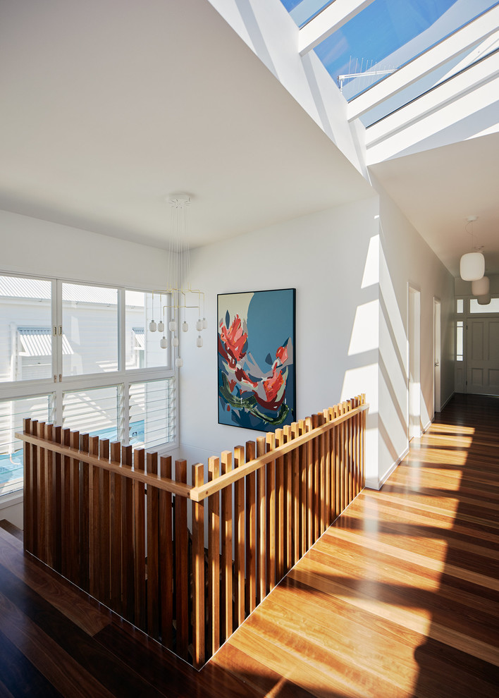 Moderner Flur mit weißer Wandfarbe, braunem Holzboden und braunem Boden in Brisbane