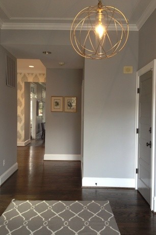Cette photo montre un couloir chic de taille moyenne avec un mur gris et parquet foncé.