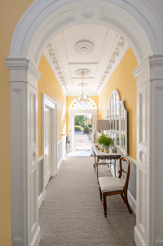 На фото: коридор среднего размера в классическом стиле с желтыми стенами и ковровым покрытием с