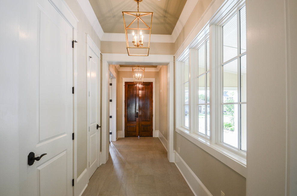 Example of a mid-sized classic porcelain tile and beige floor hallway design in New Orleans with beige walls