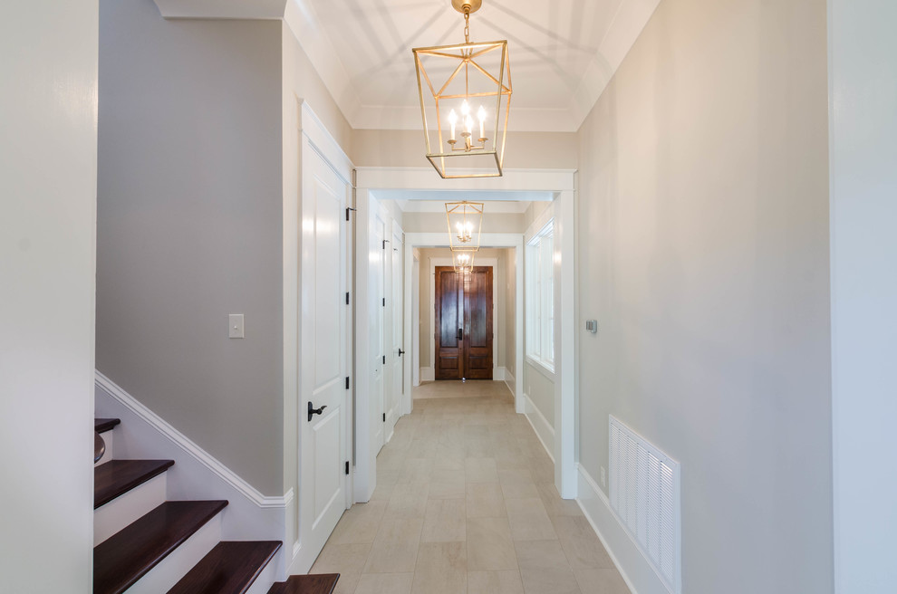 Inspiration for a mid-sized timeless porcelain tile and beige floor hallway remodel in New Orleans with beige walls