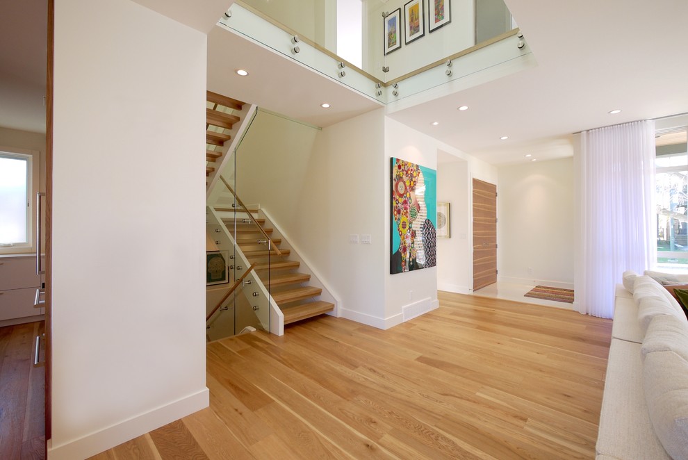 Inspiration pour un couloir minimaliste de taille moyenne avec un mur blanc et un sol en bois brun.