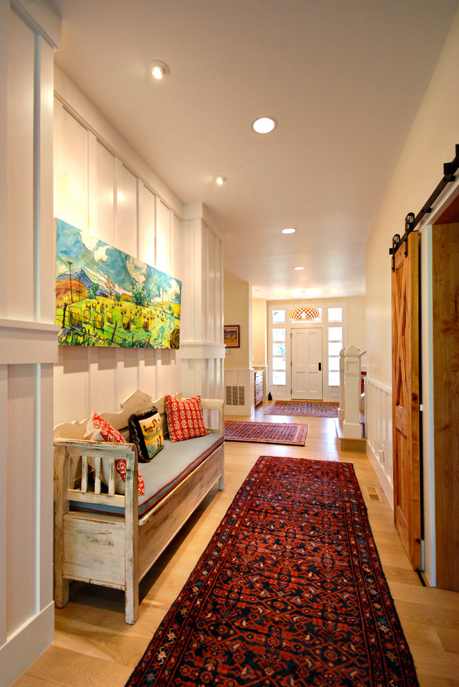 Cette photo montre un couloir nature de taille moyenne avec un mur blanc, un sol en bois brun et un sol marron.