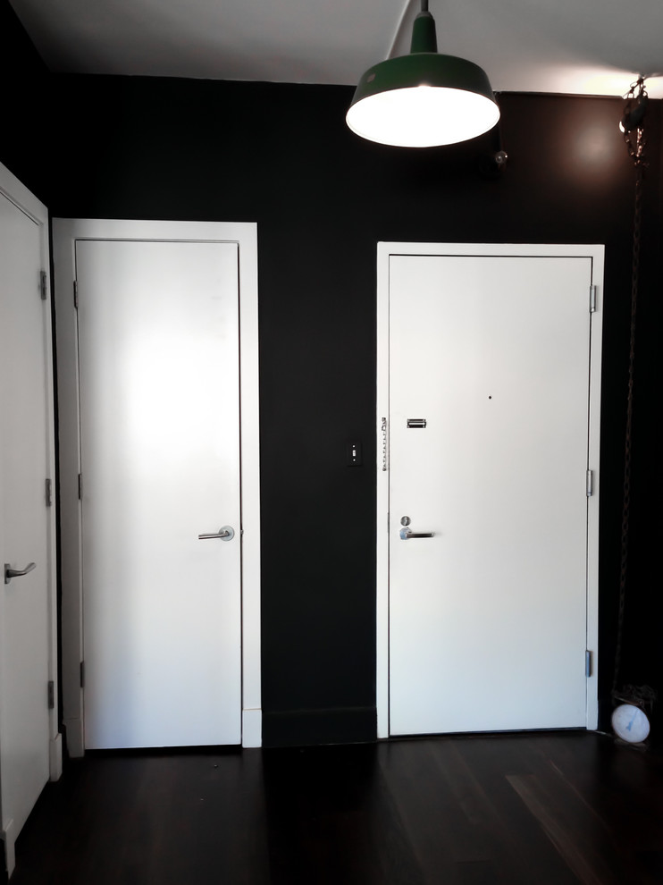 На фото: коридор среднего размера в стиле лофт с черными стенами и темным паркетным полом с