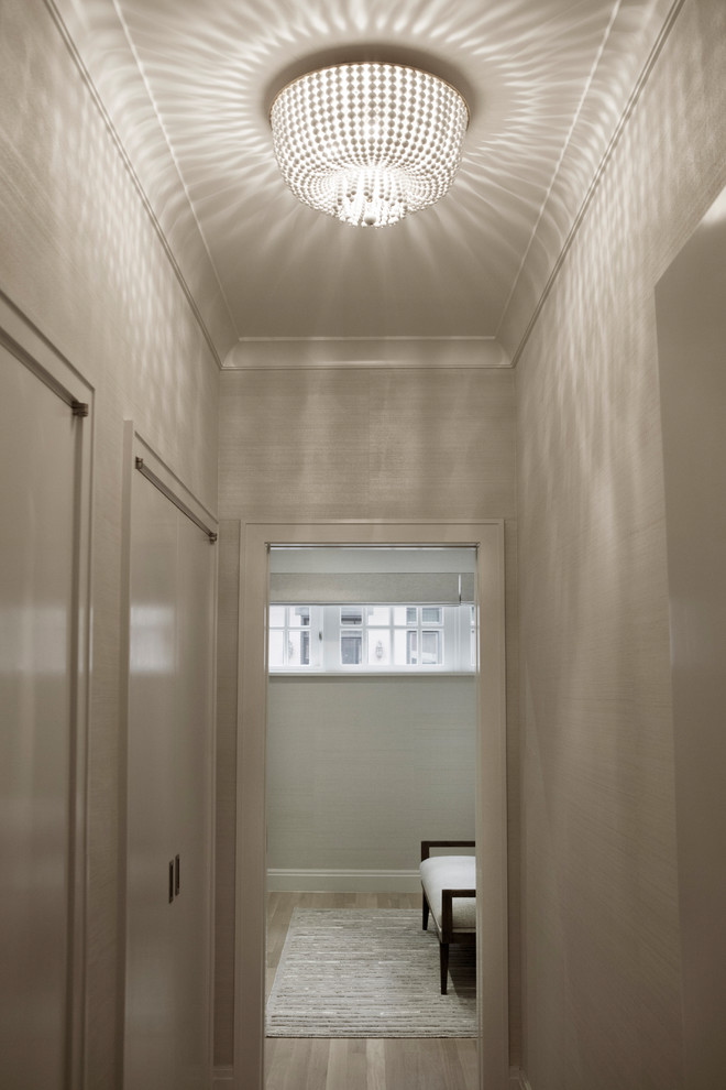 Mittelgroßer Moderner Flur mit weißer Wandfarbe, hellem Holzboden und beigem Boden in New York
