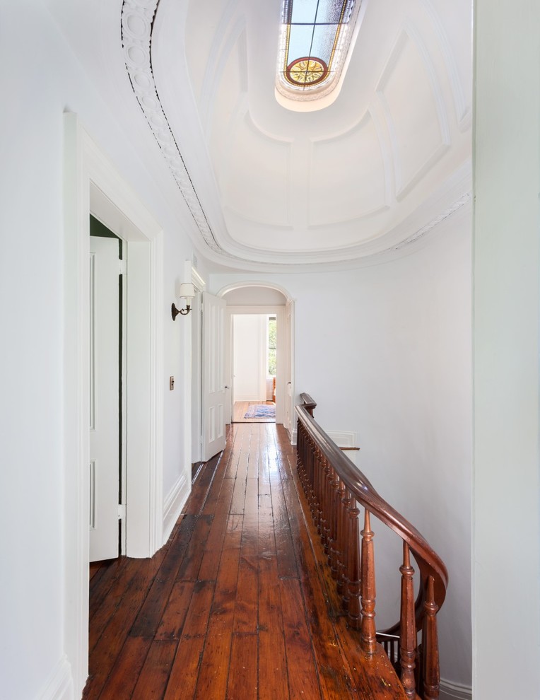 Immagine di un ingresso o corridoio tradizionale con pareti bianche e pavimento in legno massello medio