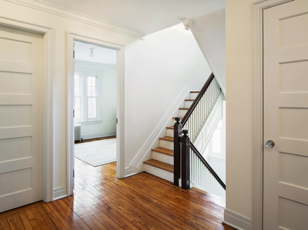 Inspiration pour un couloir style shabby chic de taille moyenne avec un mur blanc et un sol en bois brun.