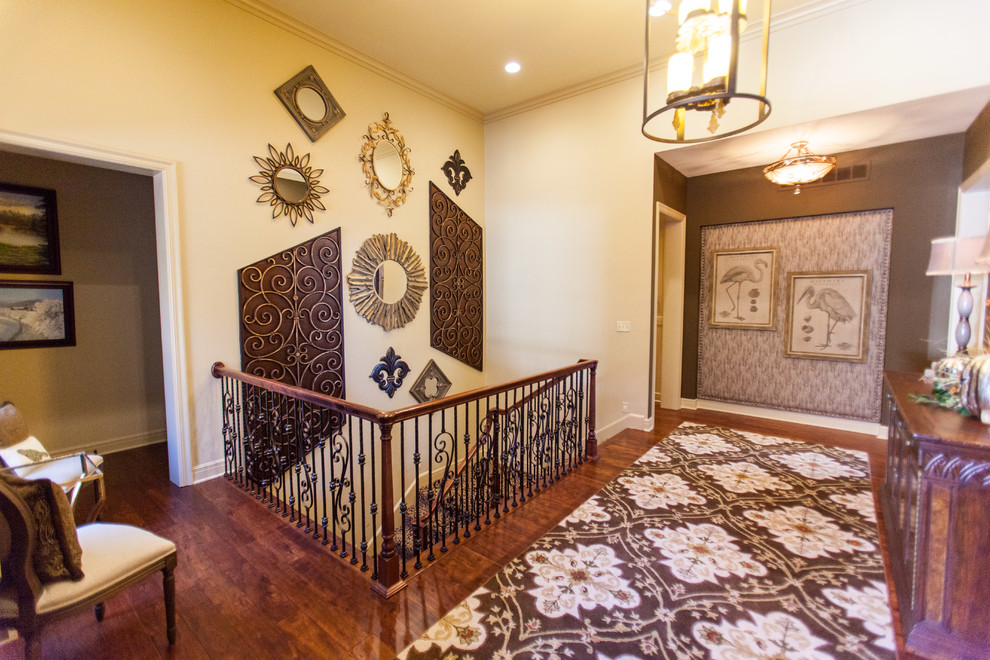 Réalisation d'un grand couloir tradition avec un mur beige, un sol en bois brun et un sol marron.