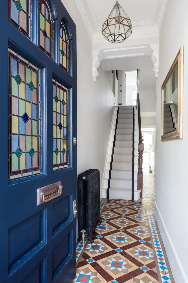 Mid-sized elegant multicolored floor hallway photo in London with white walls
