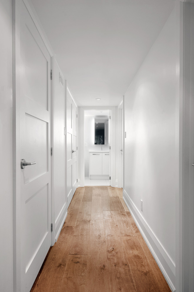 На фото: маленький коридор в стиле неоклассика (современная классика) с белыми стенами и паркетным полом среднего тона для на участке и в саду