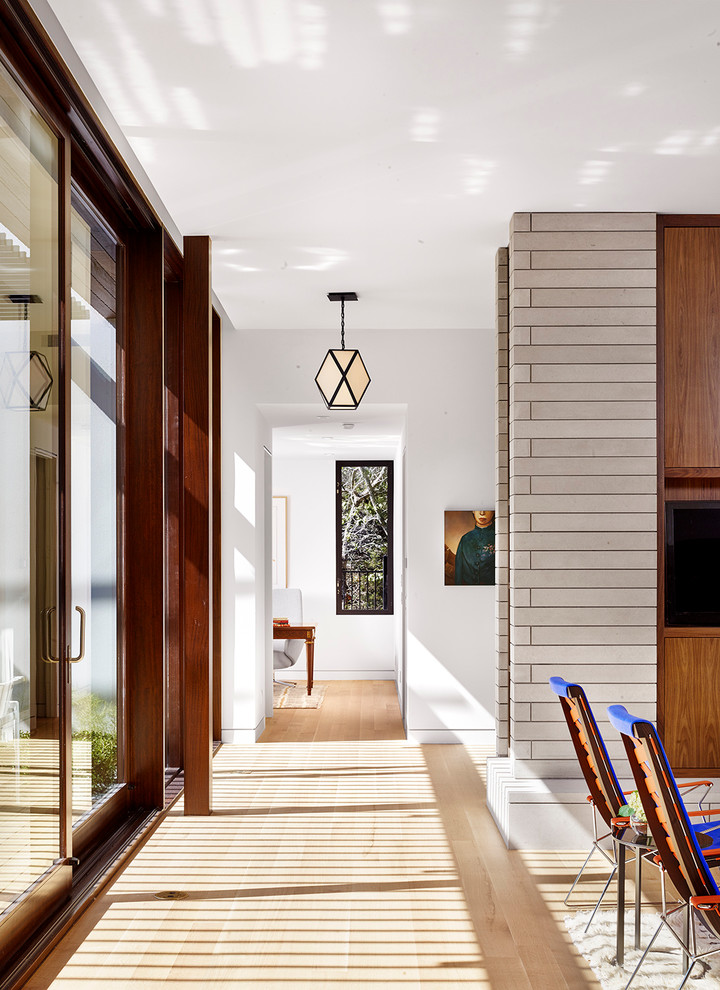 Стильный дизайн: коридор в современном стиле с белыми стенами и светлым паркетным полом - последний тренд