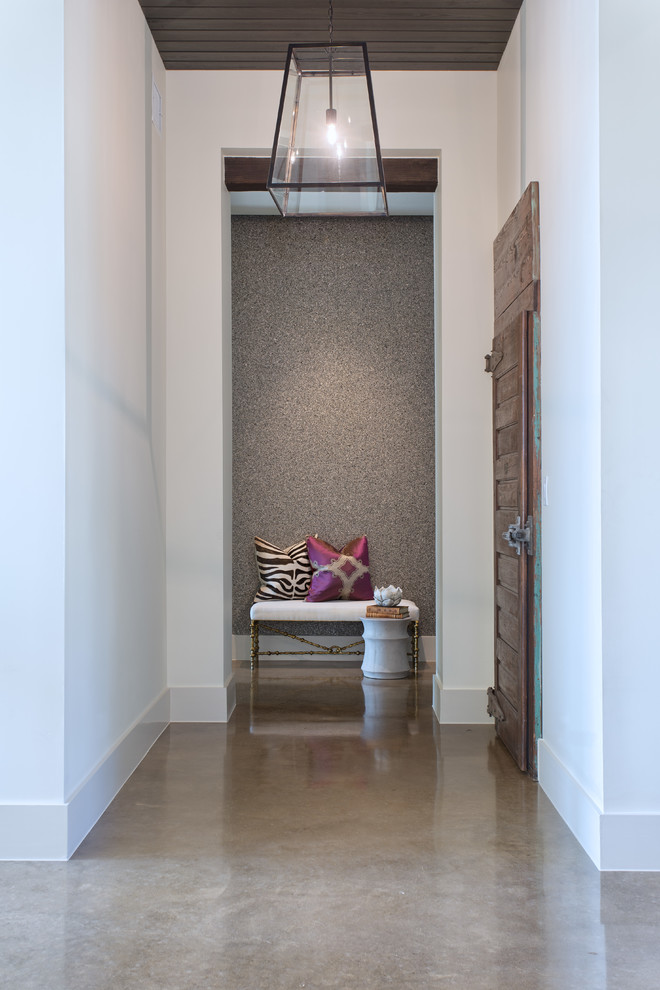 На фото: коридор в стиле неоклассика (современная классика) с белыми стенами и бетонным полом