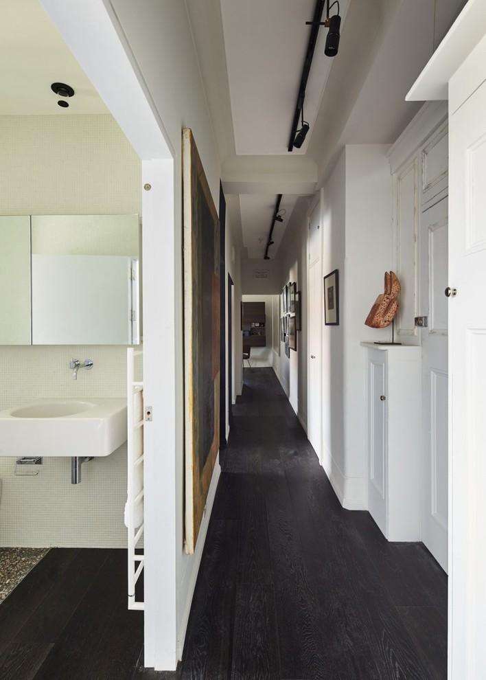 На фото: маленький, узкий коридор в современном стиле с белыми стенами, темным паркетным полом и черным полом для на участке и в саду