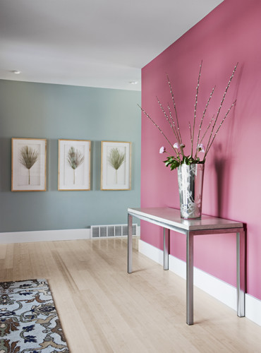 Cette image montre un couloir design de taille moyenne avec un mur rose et parquet clair.
