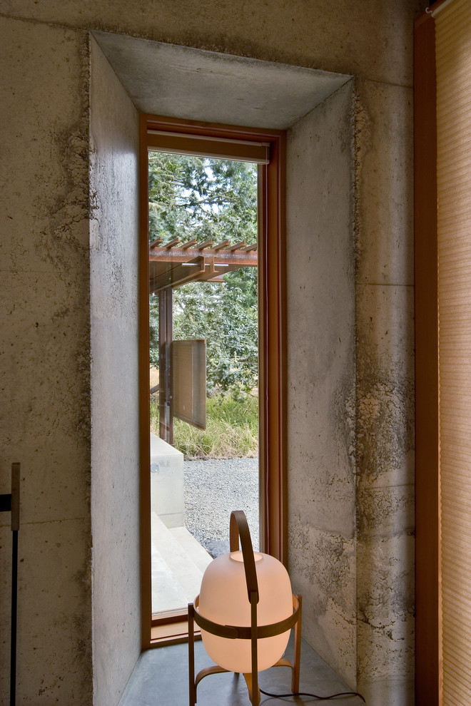 Idee per un piccolo ingresso o corridoio minimalista con pareti grigie e pavimento in cemento