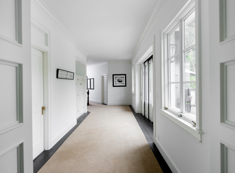 Ejemplo de recibidores y pasillos clásicos renovados grandes con paredes blancas, suelo de madera oscura y suelo beige