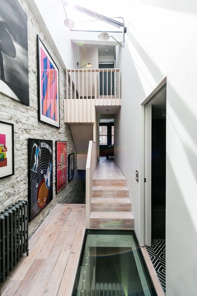 Mittelgroßer Moderner Flur mit weißer Wandfarbe und hellem Holzboden in London
