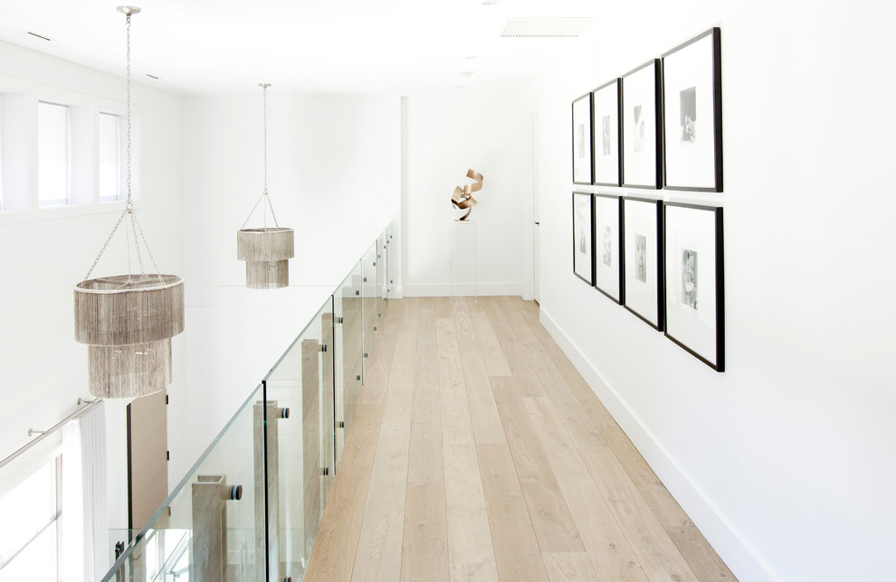 Inspiration for a large contemporary light wood floor hallway remodel in Vancouver with white walls