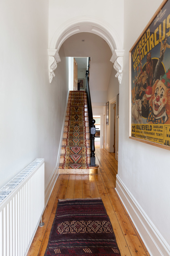 Immagine di un grande ingresso o corridoio vittoriano con pareti bianche e parquet chiaro