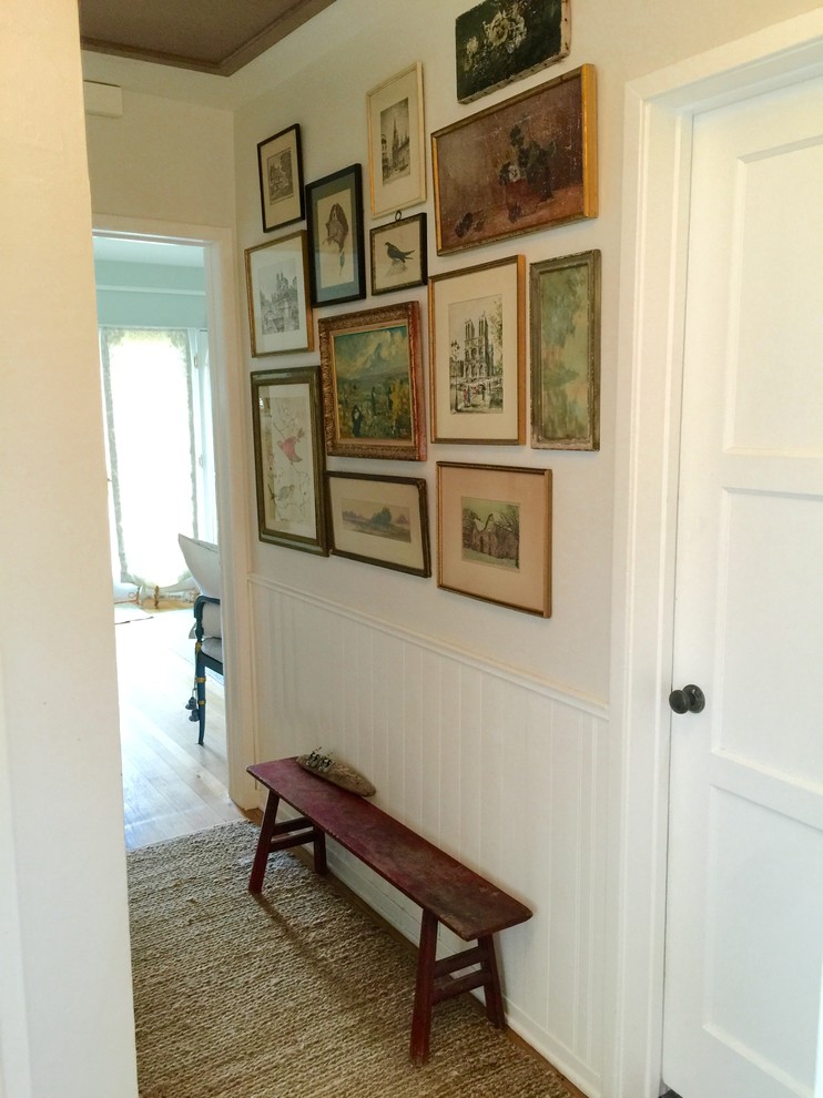 Inspiration för en liten vintage hall, med gula väggar och ljust trägolv