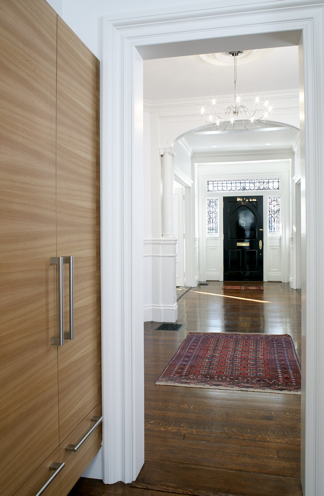 Aménagement d'un couloir classique avec un mur blanc et un sol marron.