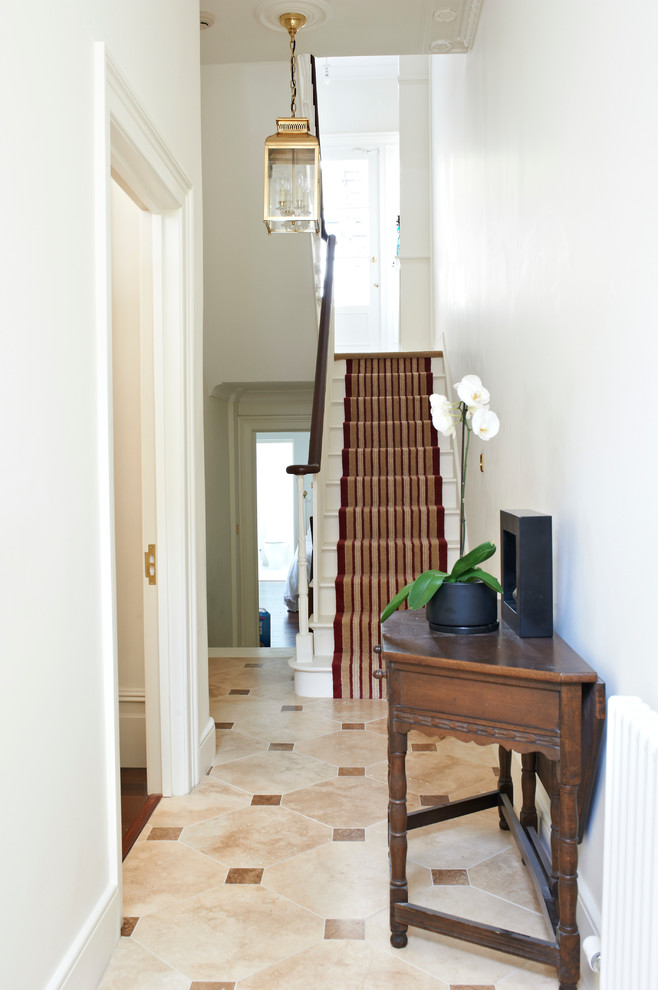 На фото: коридор в современном стиле с белыми стенами и полом из керамической плитки с