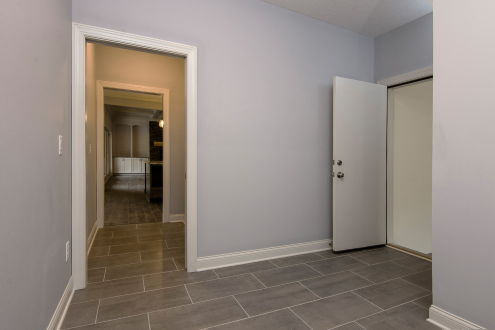 Aménagement d'un couloir campagne avec un mur beige, un sol en carrelage de céramique et un sol gris.