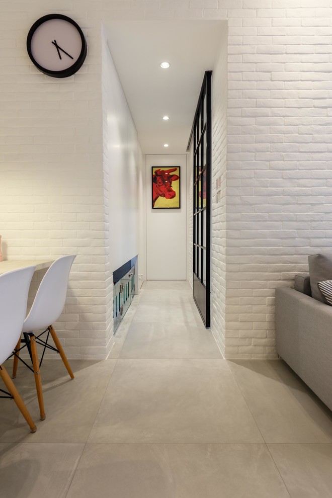 Idée de décoration pour un couloir minimaliste avec un mur blanc et un sol en carrelage de céramique.