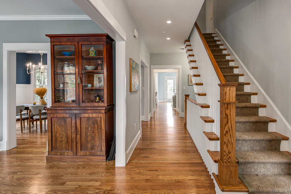 Cette photo montre un couloir craftsman de taille moyenne avec un mur gris et un sol en bois brun.
