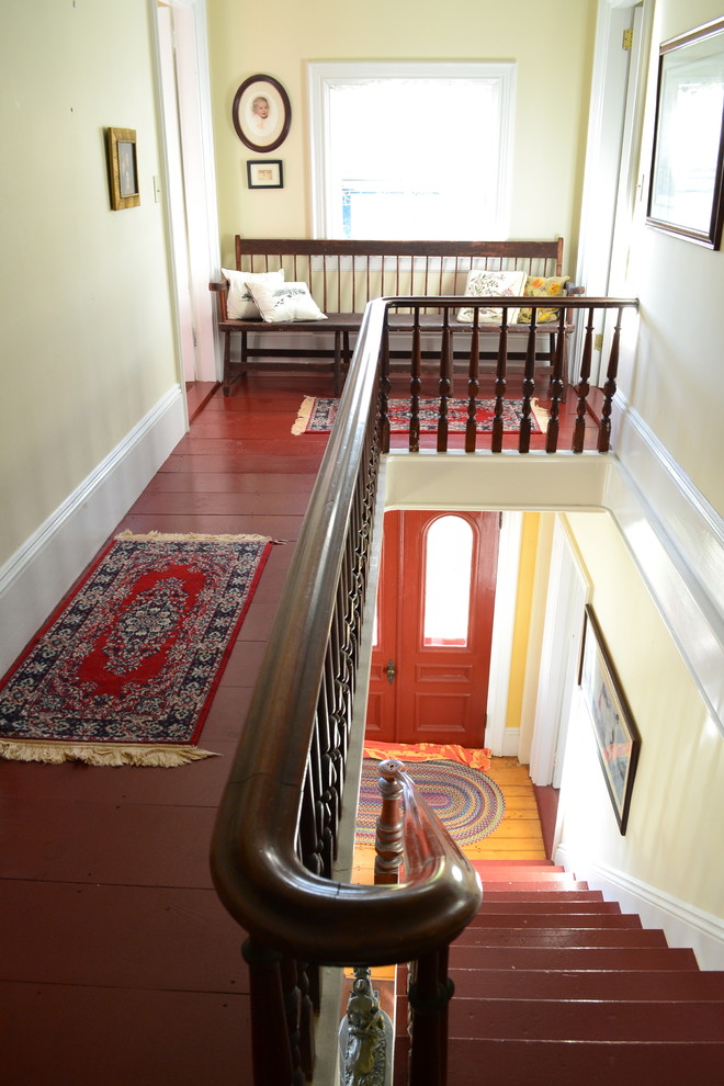 Mittelgroßer Klassischer Flur mit gelber Wandfarbe und gebeiztem Holzboden in Boston