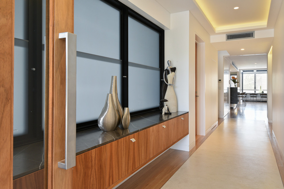 Ispirazione per un grande ingresso o corridoio minimalista con pareti bianche, parquet chiaro e pavimento marrone