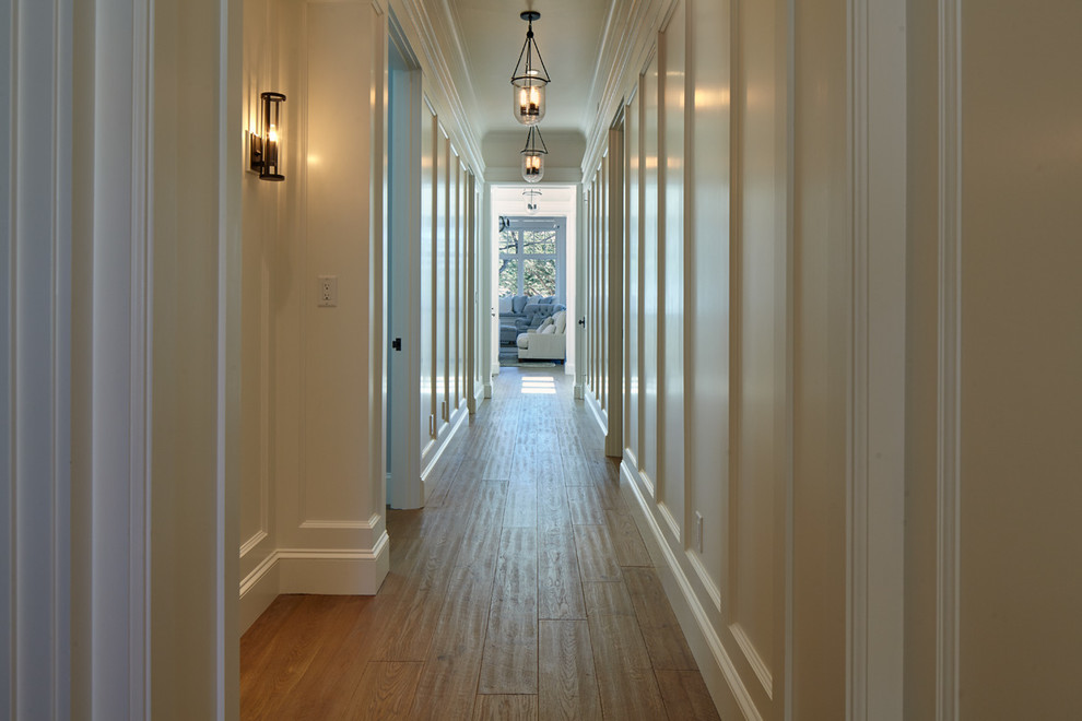 Foto de recibidores y pasillos costeros de tamaño medio con paredes blancas y suelo de madera en tonos medios