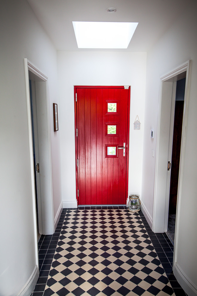 Esempio di un ingresso o corridoio minimal con pareti bianche, pavimento con piastrelle in ceramica e pavimento nero