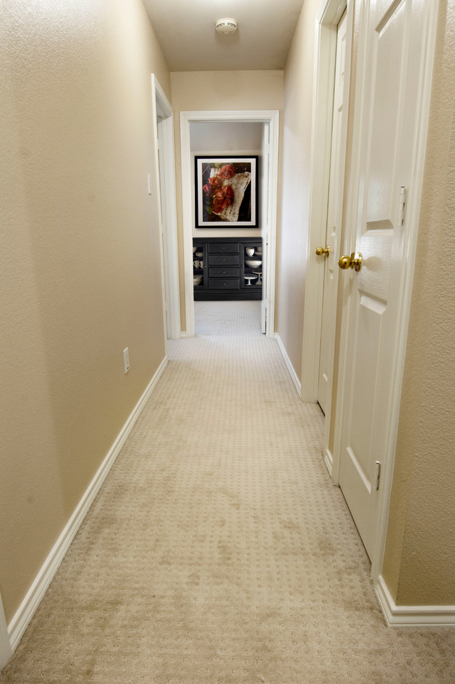 Example of a mid-sized transitional carpeted hallway design in Dallas with beige walls