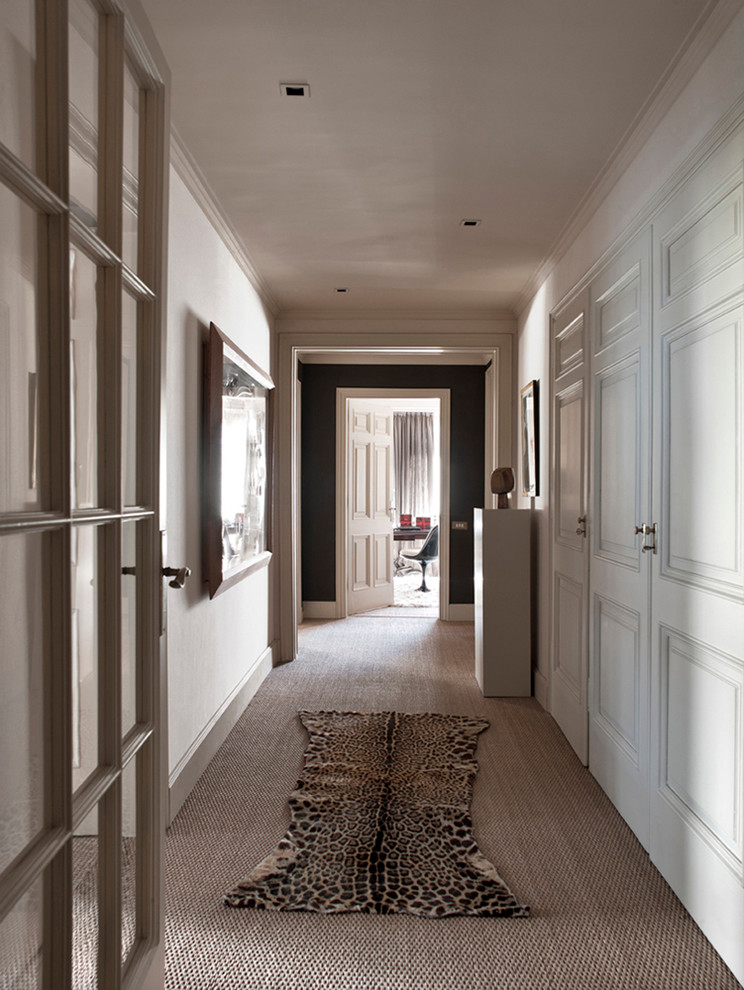 Aménagement d'un grand couloir classique avec un mur blanc et moquette.