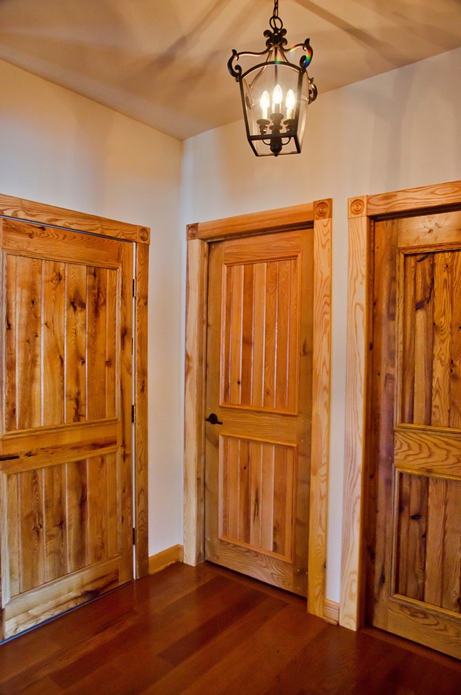 Ejemplo de recibidores y pasillos rurales de tamaño medio con paredes beige, suelo de madera en tonos medios y suelo marrón