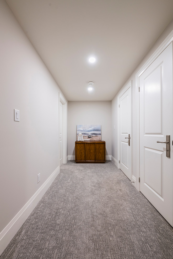 Idée de décoration pour un couloir minimaliste de taille moyenne avec un mur blanc, moquette et un sol gris.