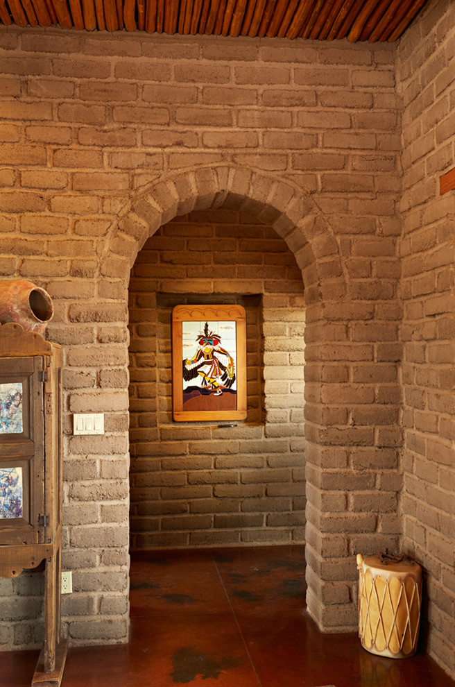 Cette image montre un grand couloir sud-ouest américain avec un mur marron et sol en béton ciré.