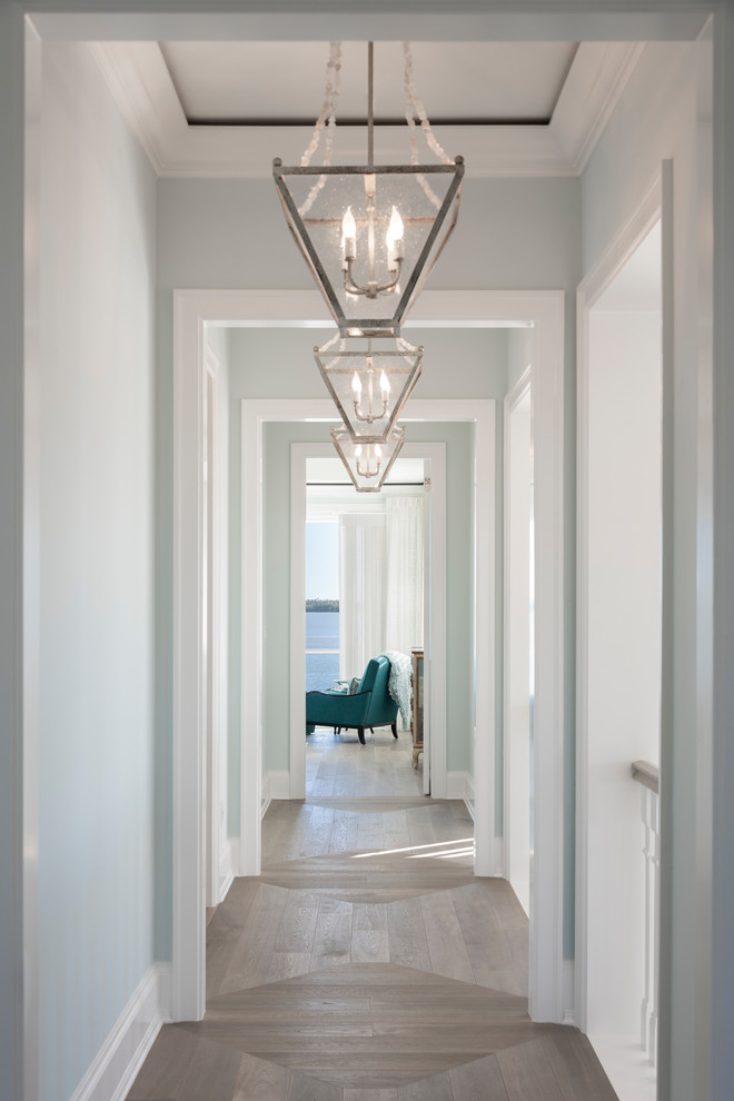 На фото: коридор в стиле неоклассика (современная классика) с синими стенами, паркетным полом среднего тона и коричневым полом