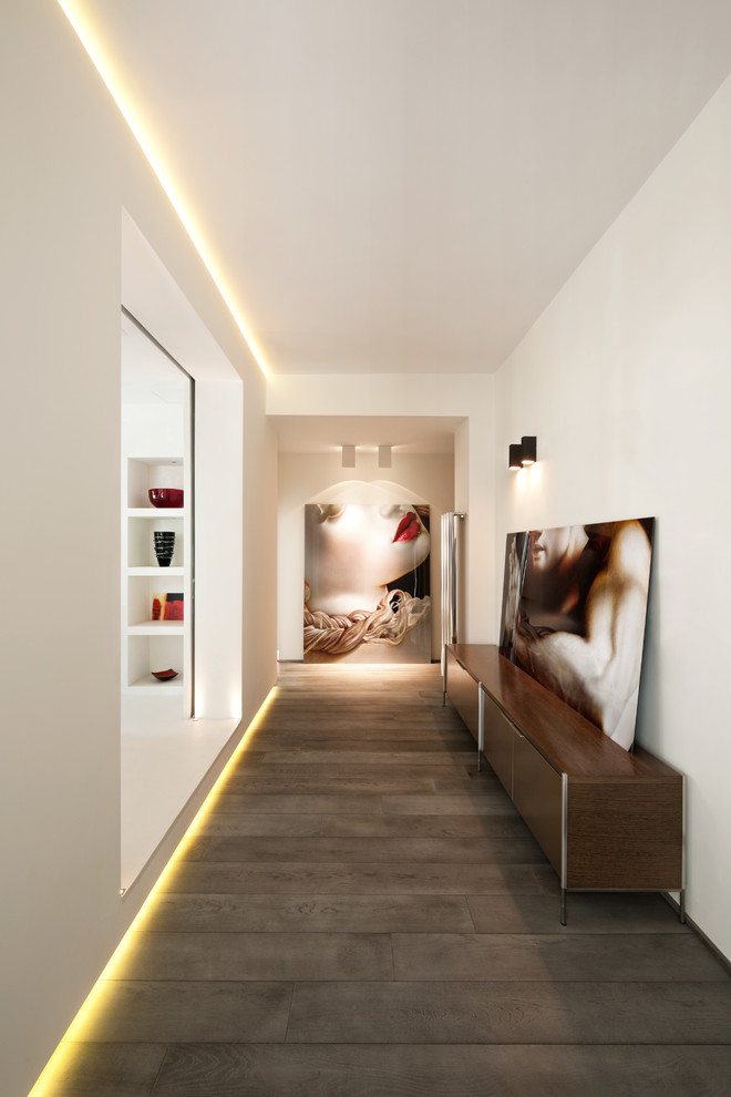 Стильный дизайн: коридор в современном стиле с белыми стенами и темным паркетным полом - последний тренд
