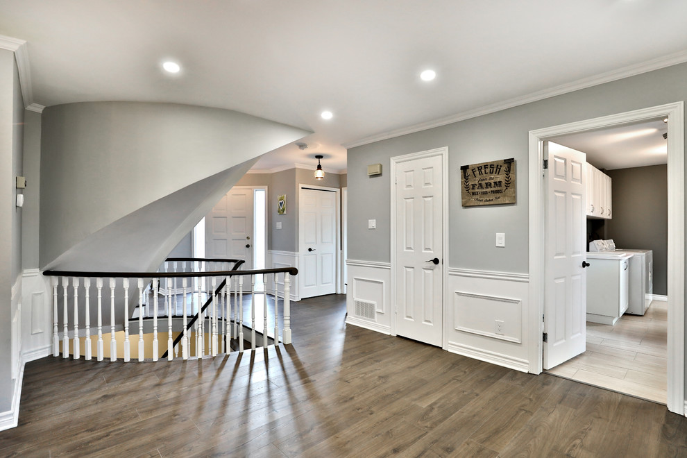 Esempio di un ingresso o corridoio minimalista di medie dimensioni con pareti grigie e pavimento in legno massello medio