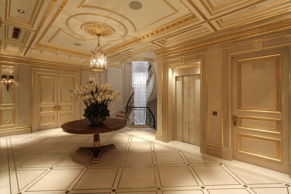 ラグジュアリーな巨大なトランジショナルスタイルのおしゃれな廊下 (ベージュの壁、大理石の床、ベージュの床) の写真