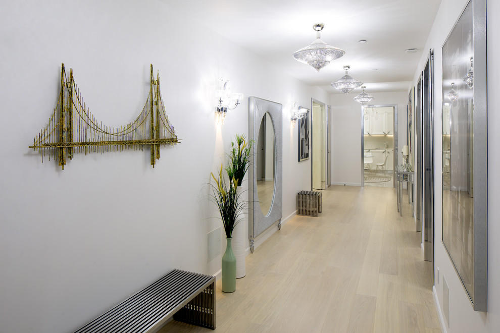 Réalisation d'un grand couloir minimaliste avec un mur blanc, parquet clair et un sol beige.